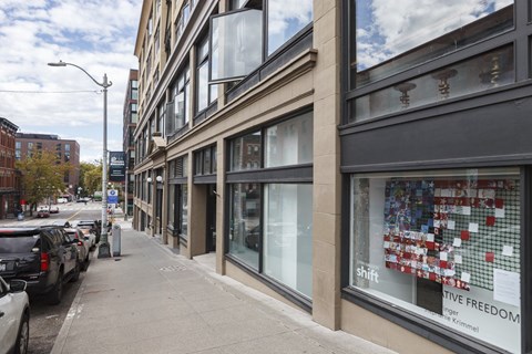 A street view of a building with a window display that reads "Shift Creative Freedom".