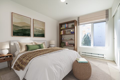 A bedroom with a large bed and two landscape paintings on the wall.