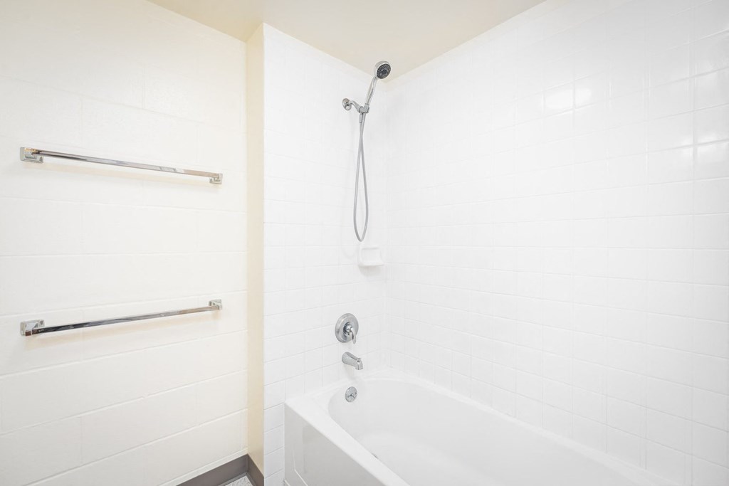 a white bathroom with a shower and a tub