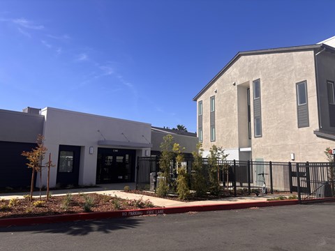 A modern building with a black gate and a red curb.