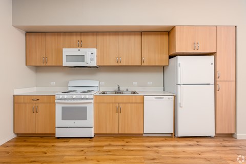 A kitchen with wooden cabinets and white appliances.