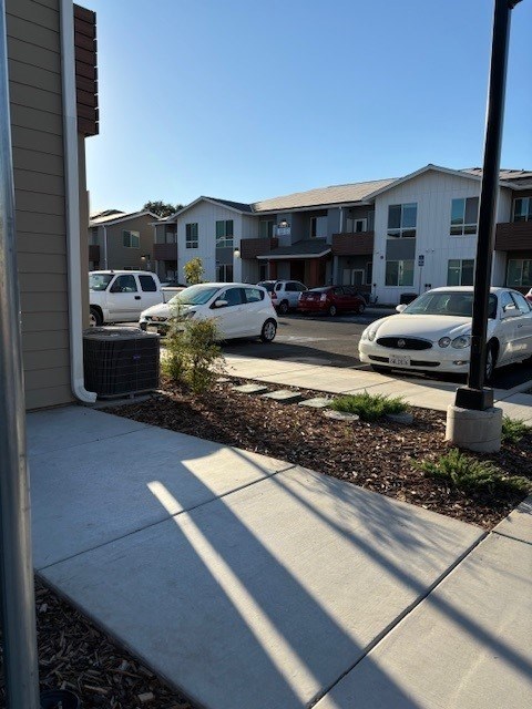 A white car is parked in front of a building.