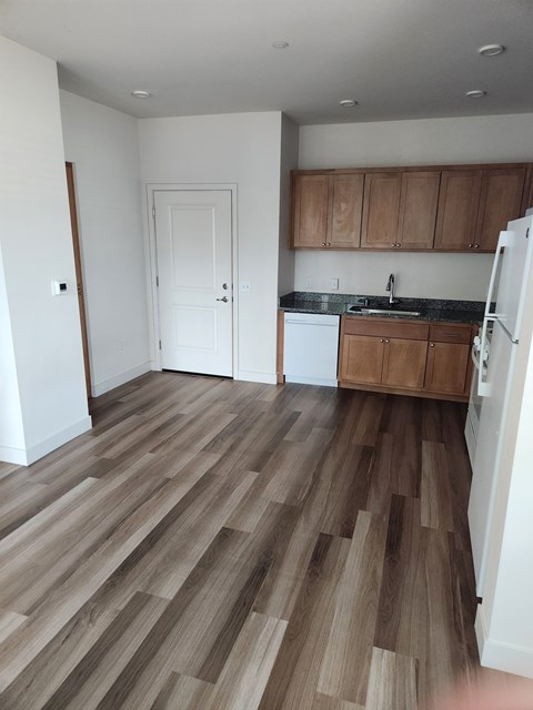 A kitchen with wooden floors and white walls.