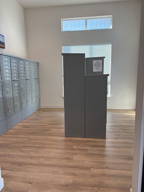 A room with a wooden floor and a cabinet with drawers.