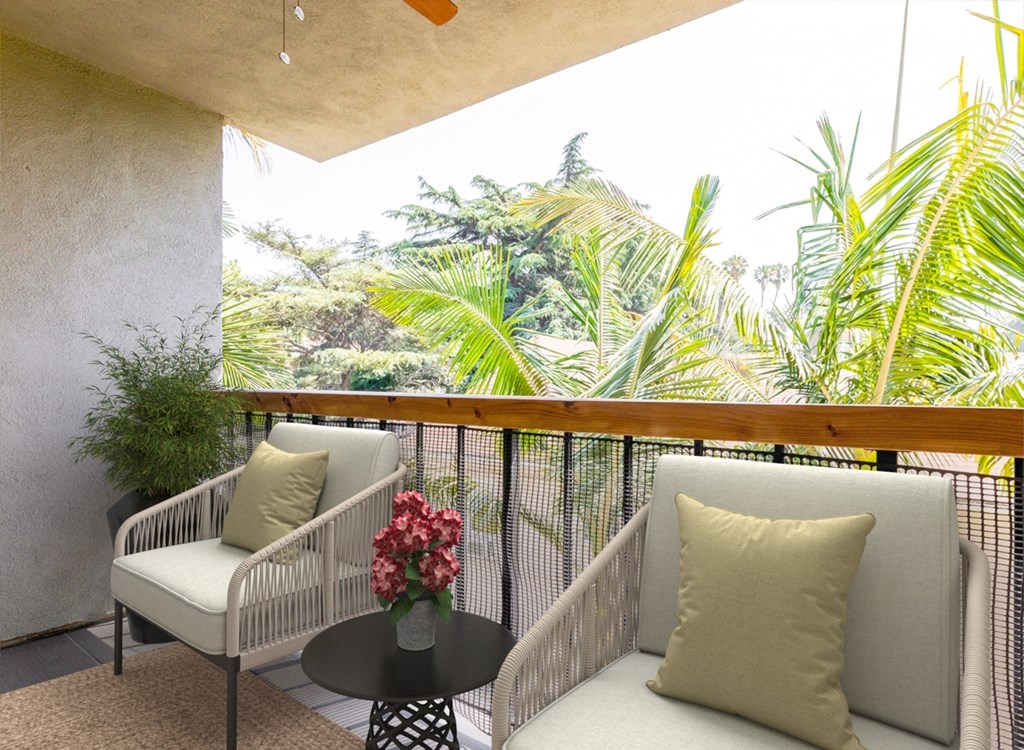 a balcony with two chairs and a table with a pillow