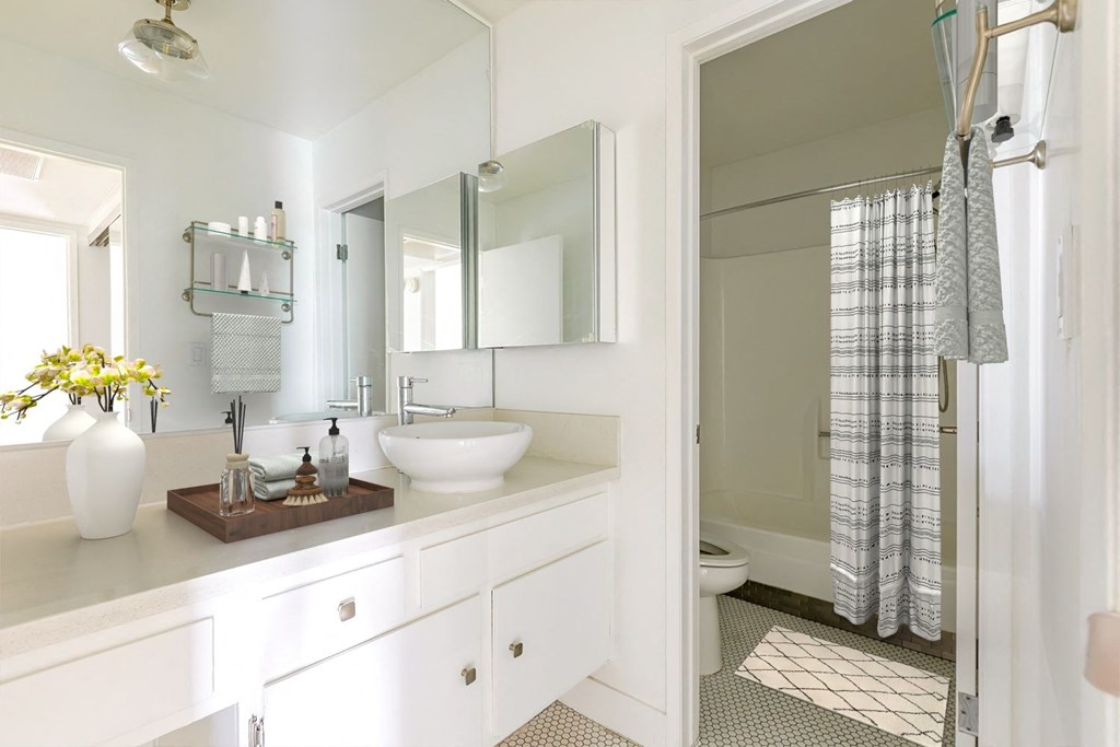 a white bathroom with a sink and a shower