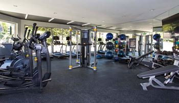 a large fitness room with cardio equipment and weights  at 888 Hilgard – Furnished Apartments, Los Angeles, CA