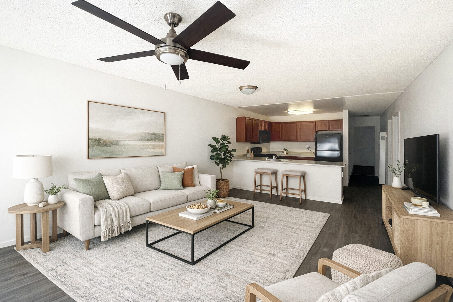 A living room with a white couch, a coffee table, and a ceiling fan.