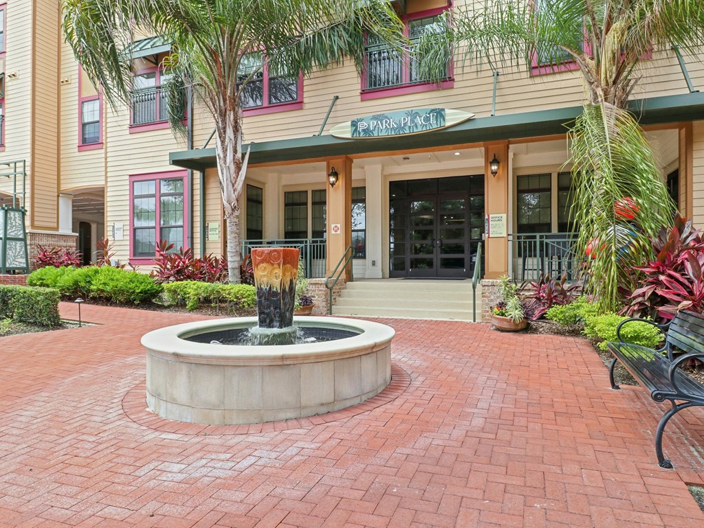 a fountain in the middle of a courtyard in front of a building