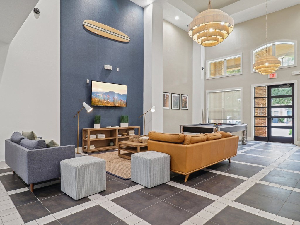 a lobby with couches and chairs and a tv