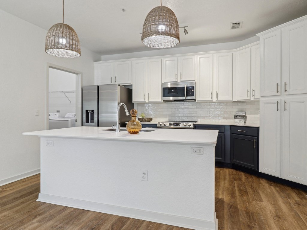 a kitchen with a large white island and black cabinets