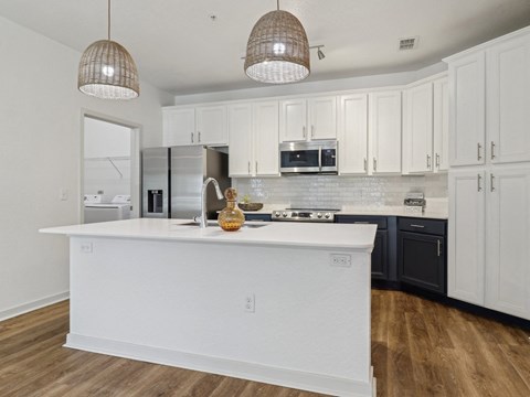 a kitchen with a large white island and black cabinets  at Park Place, Oviedo, FL, 32765