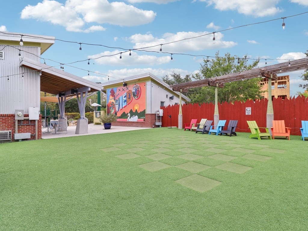 a yard with chairs and a mural on the side of a building