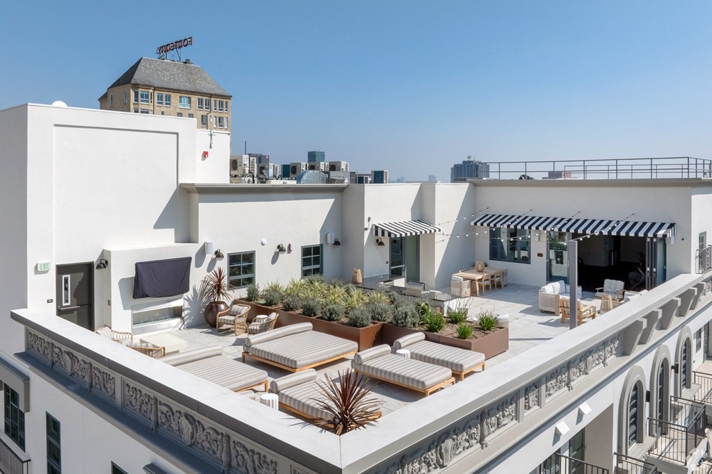a roof terrace with furniture and a city in the background