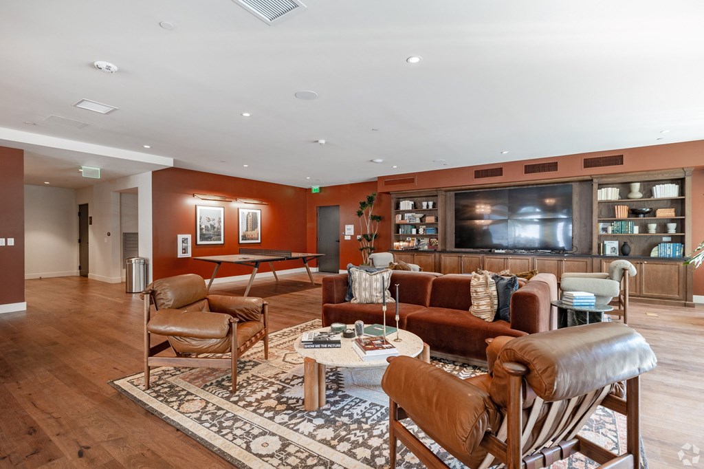 a living room with couches and chairs and a television