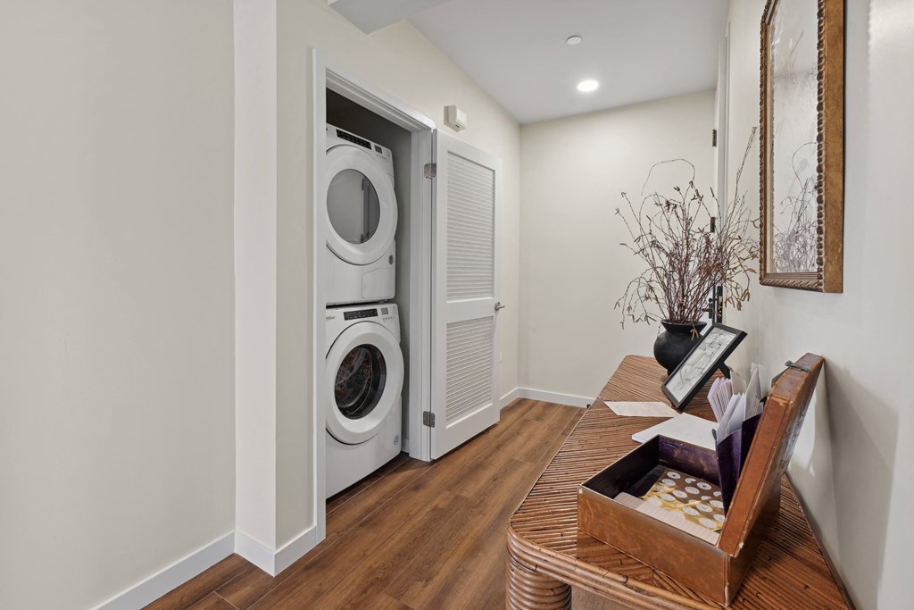 a living room with a table and a washer and dryer in a door
