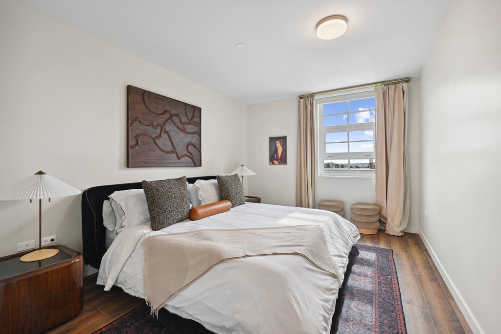 bedroom with white walls and a large bed and a window