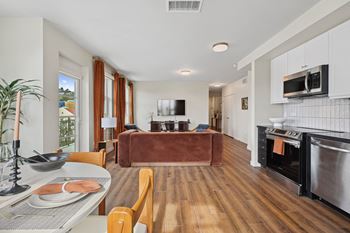 a living room with a leather couch and a table with chairs
