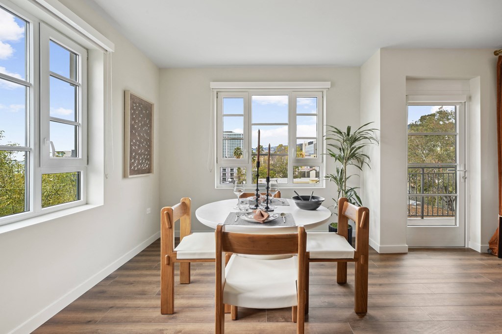 a dining room with a table and chairs and windows