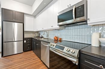 a kitchen with white cabinets and stainless steel appliances