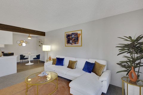 A living room with a white couch and a yellow coffee table.