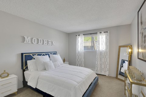 A bedroom with a large bed and a mirror on the wall.