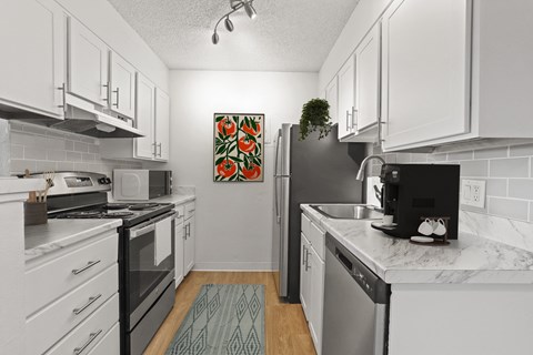 A kitchen with white cabinets and a black fridge.