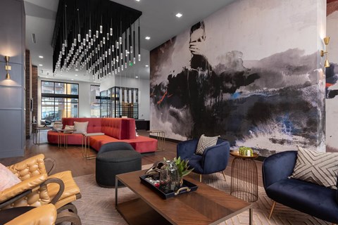 A modern living room with a large abstract painting on the wall.