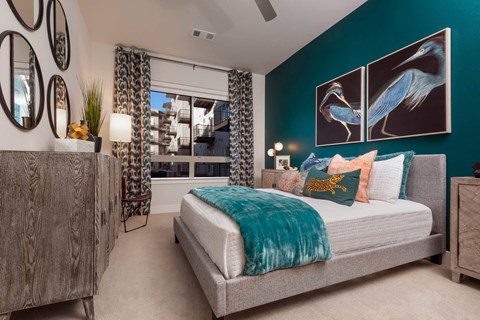 A bedroom with a bed, a dresser, and a mirror on the wall.