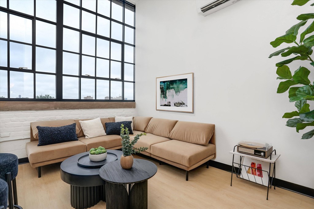 a living room with a brown couch and a large window