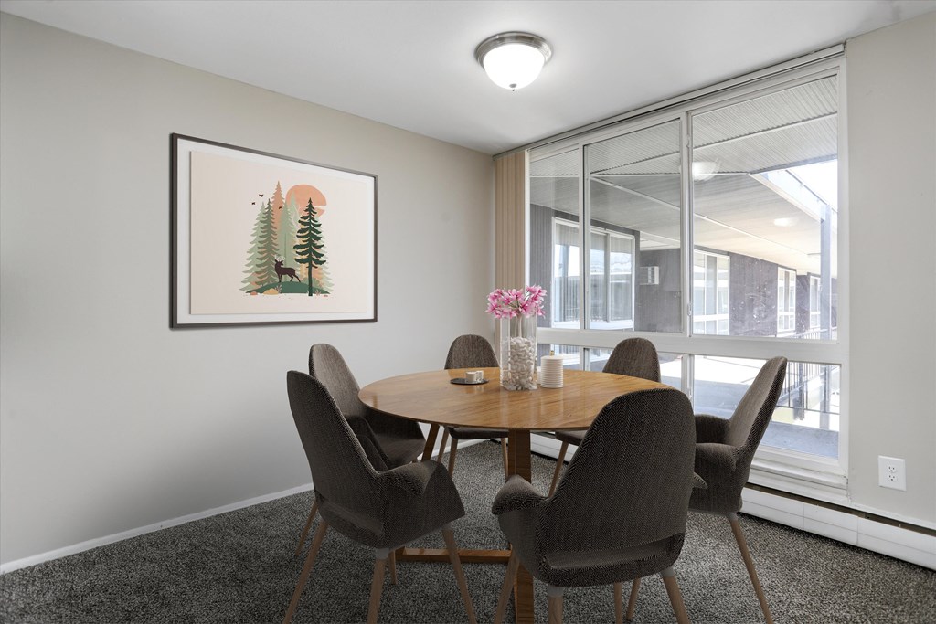 a dining area with a wooden table and chairs and a large window with a view of a