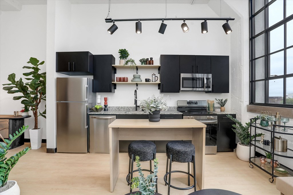 a kitchen with black and stainless steel appliances and a wooden table