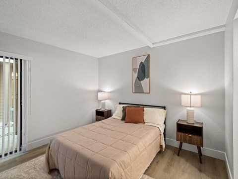 A bedroom with a large bed and two lamps.