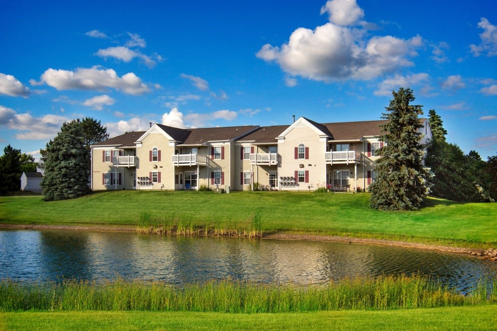 A large house with a pond in front of it.