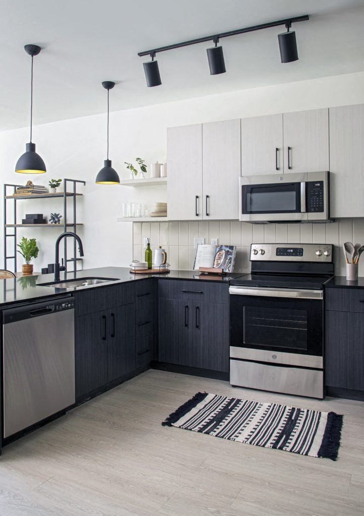 a black and white kitchen with stainless steel appliances and white cabinets