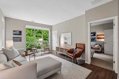 A living room with a white couch and a brown chair.