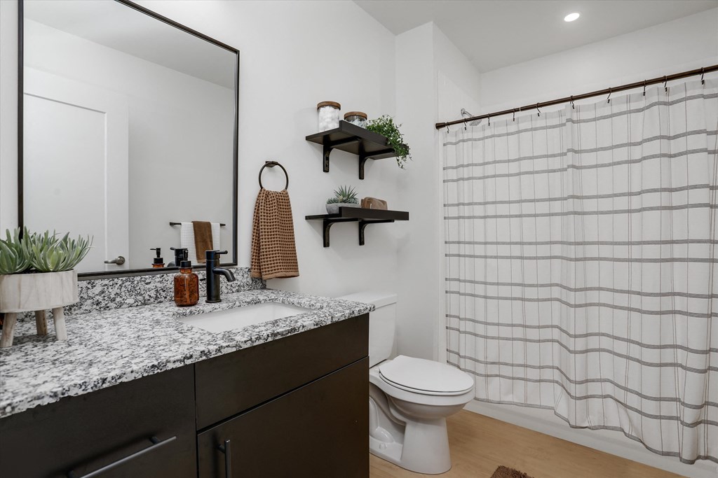 a bathroom with a shower and a sink and a toilet