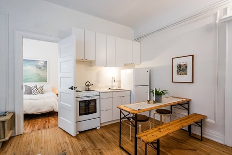 A kitchen with white cabinets and a wooden table.