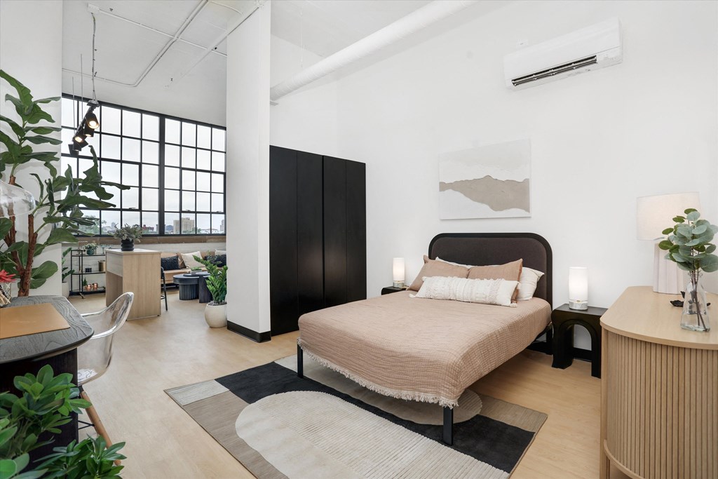 a bedroom with a bed and a large window