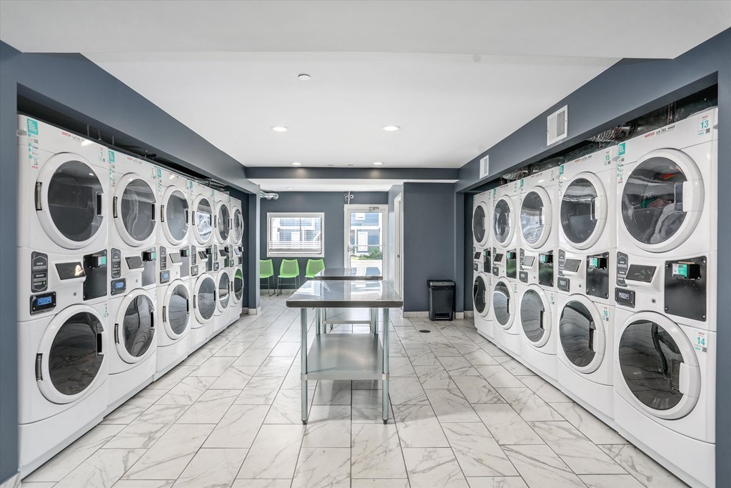 washer and dryers in a laundry room with a table in front of them