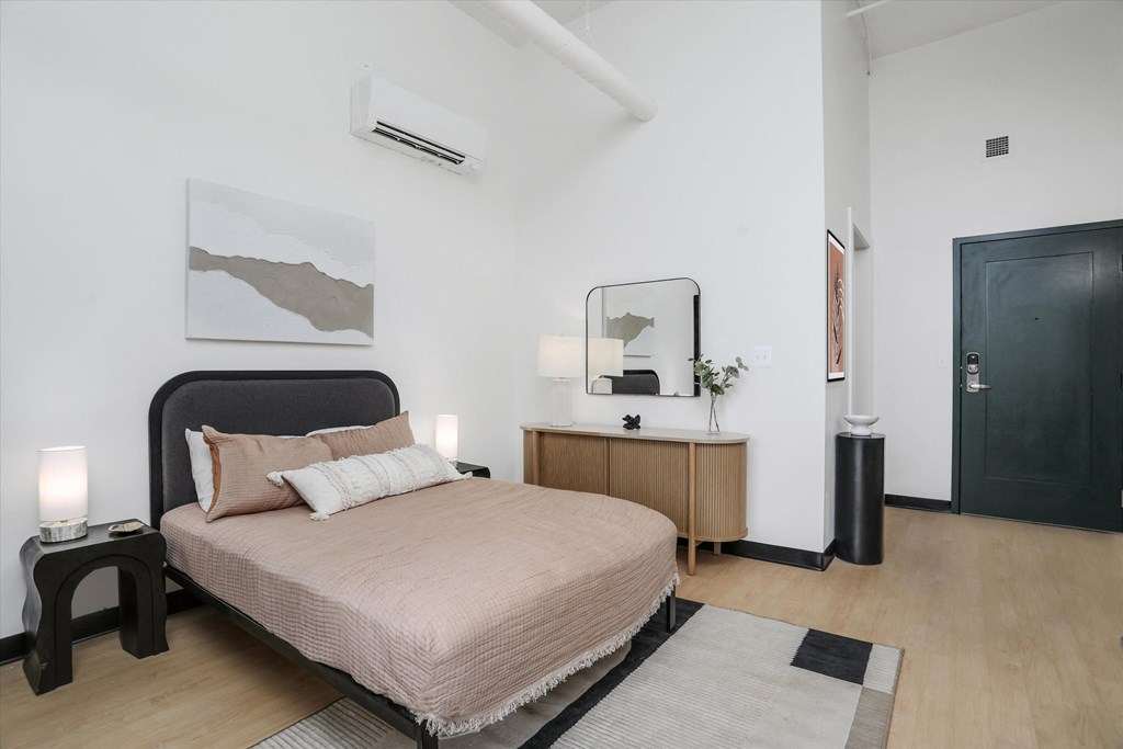 a bedroom with a bed and a dresser and a mirror