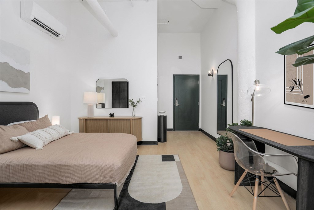 a bedroom with a bed and a desk with a mirror