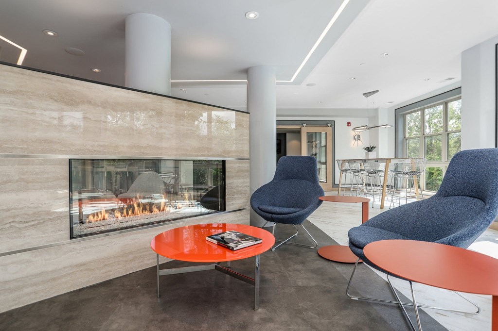 a living room with two chairs and a fireplace     and a table