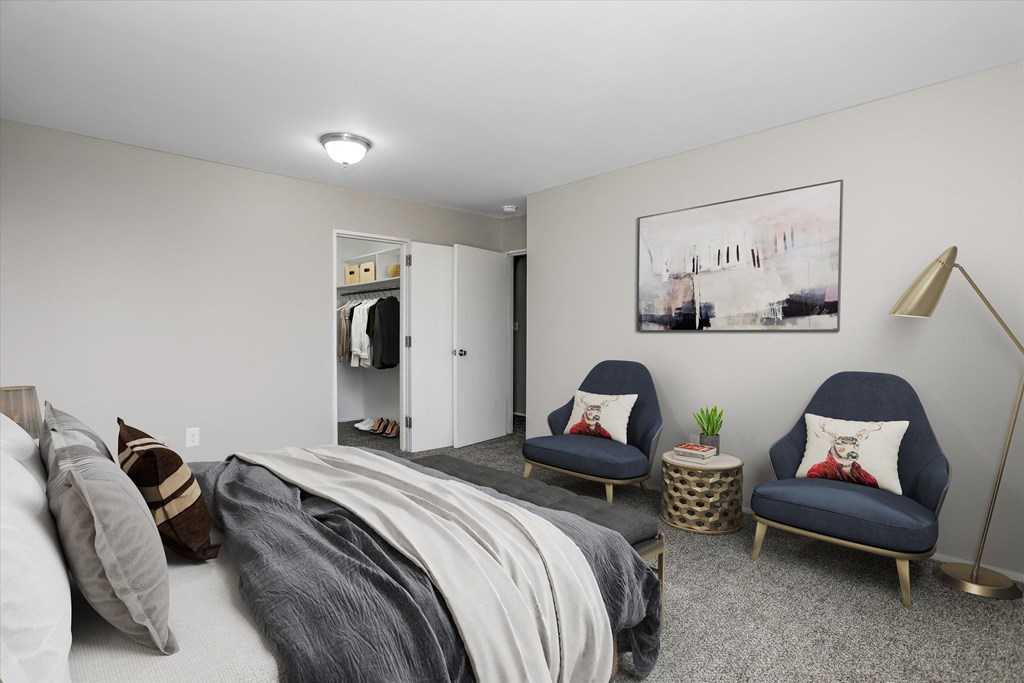 a bedroom with a bed and two chairs in a 555 waverly unit