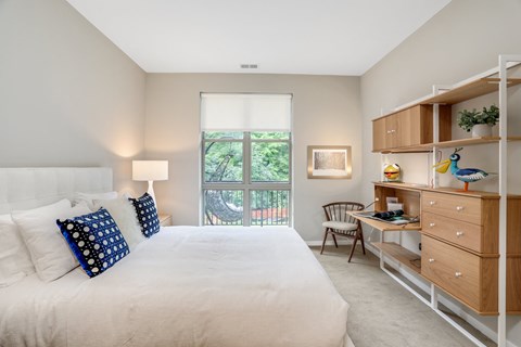 a bedroom with a bed and a desk and a window