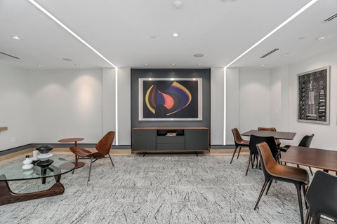 a conference room with a table and chairs and a painting on the wall