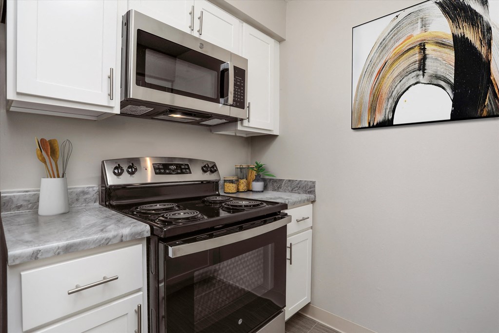 a kitchen with white cabinets and a black stove top oven