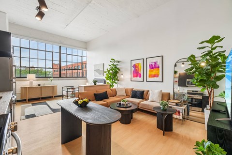 A modern living room with a black coffee table and a large window.