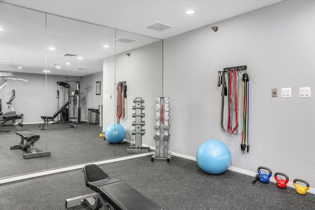 a gym with exercise equipment and mirrors on the wall