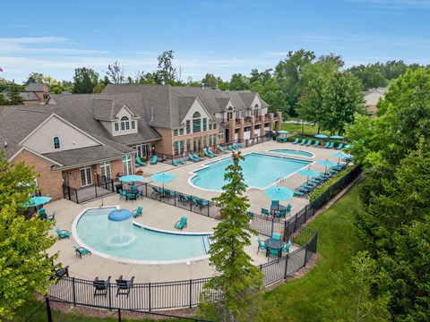 an aerial view of the resort style pool with lounge chairs and umbrellas